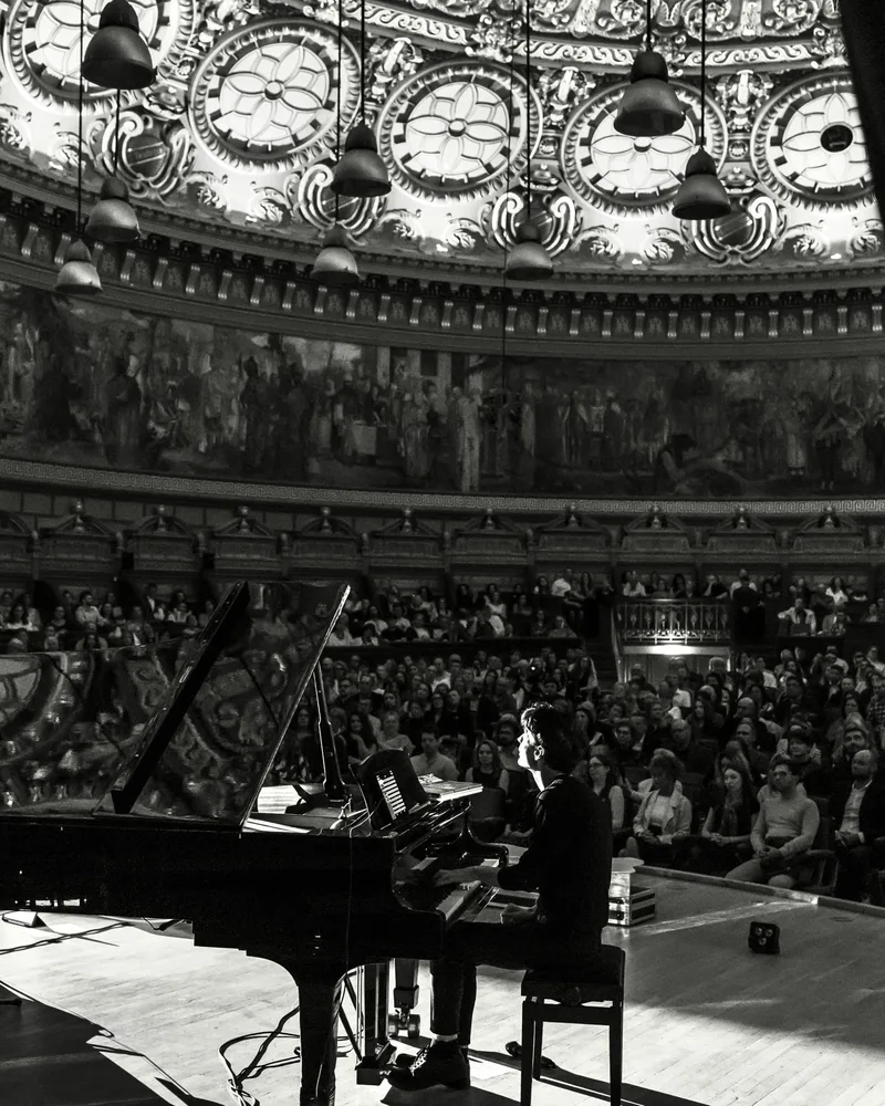 Andrei Irimia la pian, într-o sală de concert, alb-negru