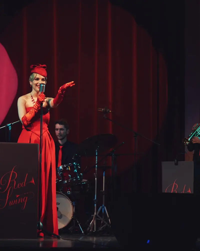Ana Maria Roșu în rochie roșie, cu Red Swing pe scenă