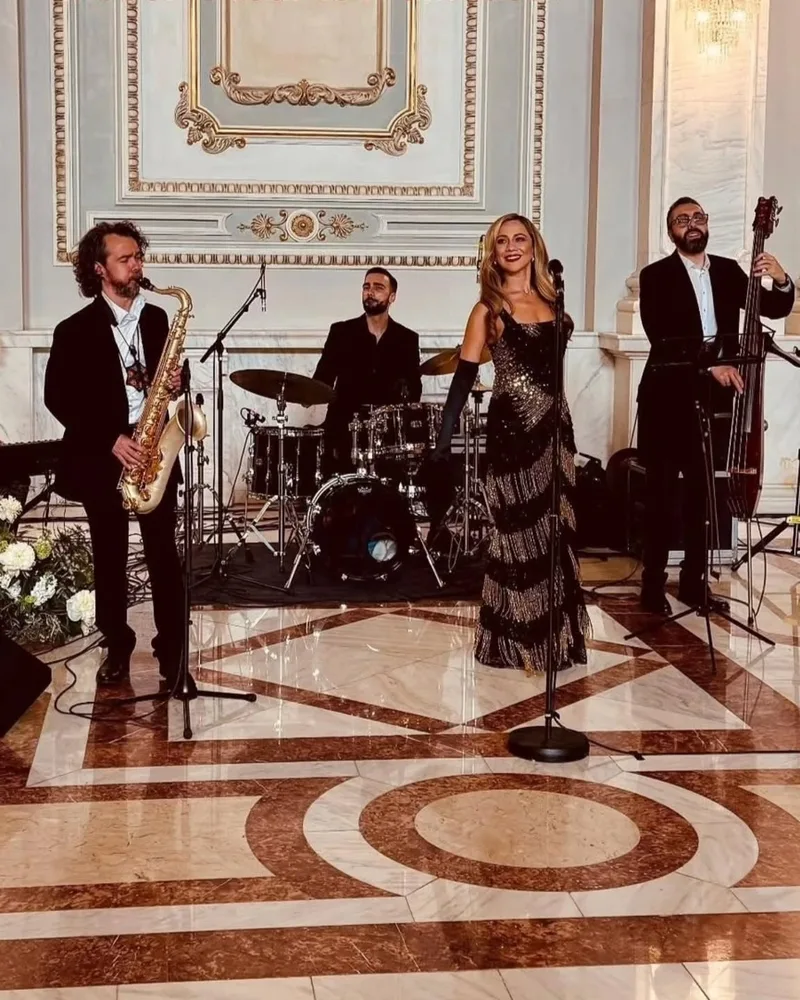 Viorica Pintilie cântând cu trupa într-o sală elegantă