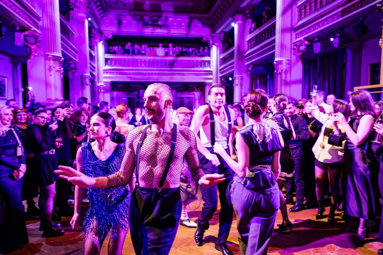 Dansatori în lumină violetă, în mijlocul publicului, la Marele Gatsby